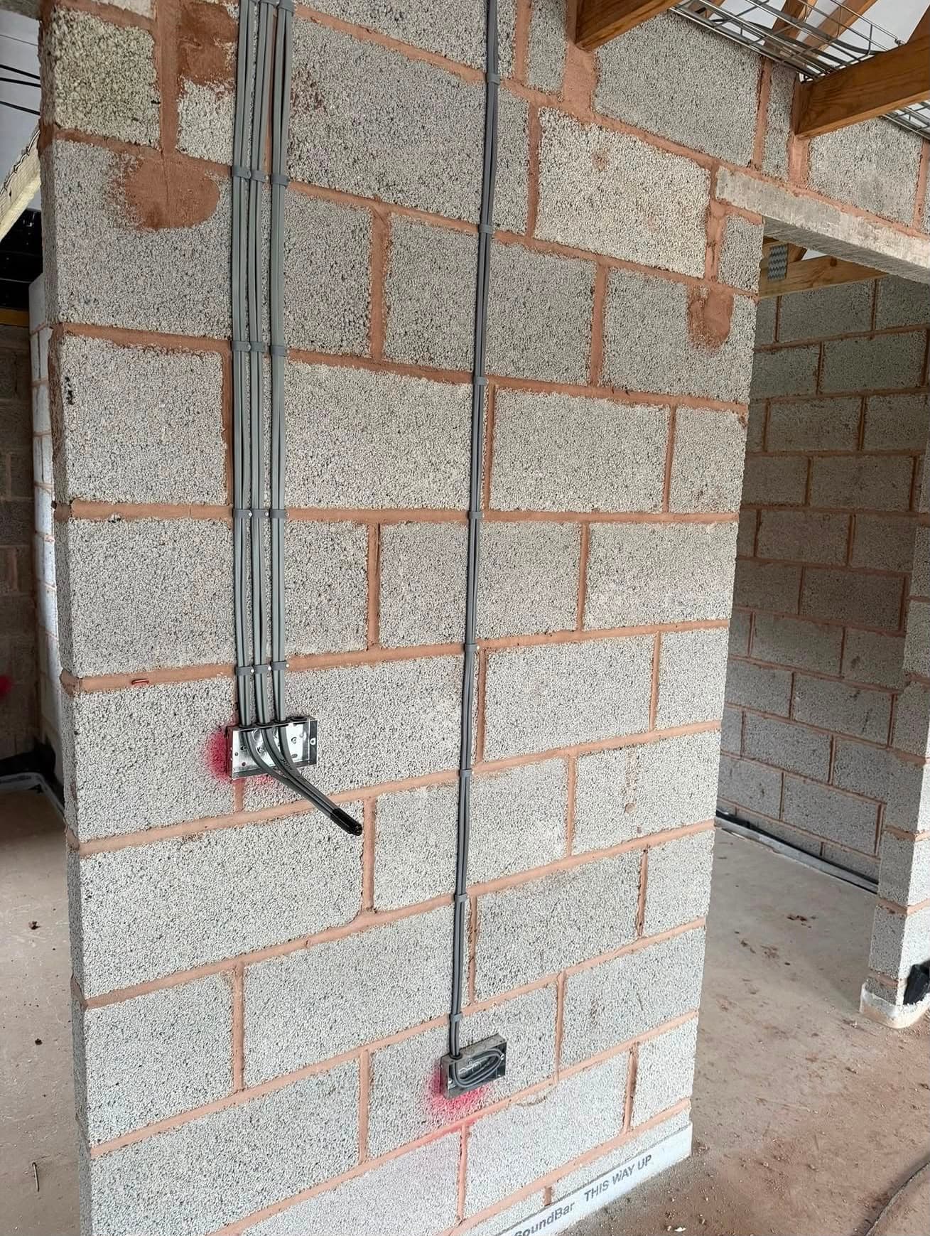 First-fix domestic electrical installation — conduits and sockets neatly routed on a new-build wall