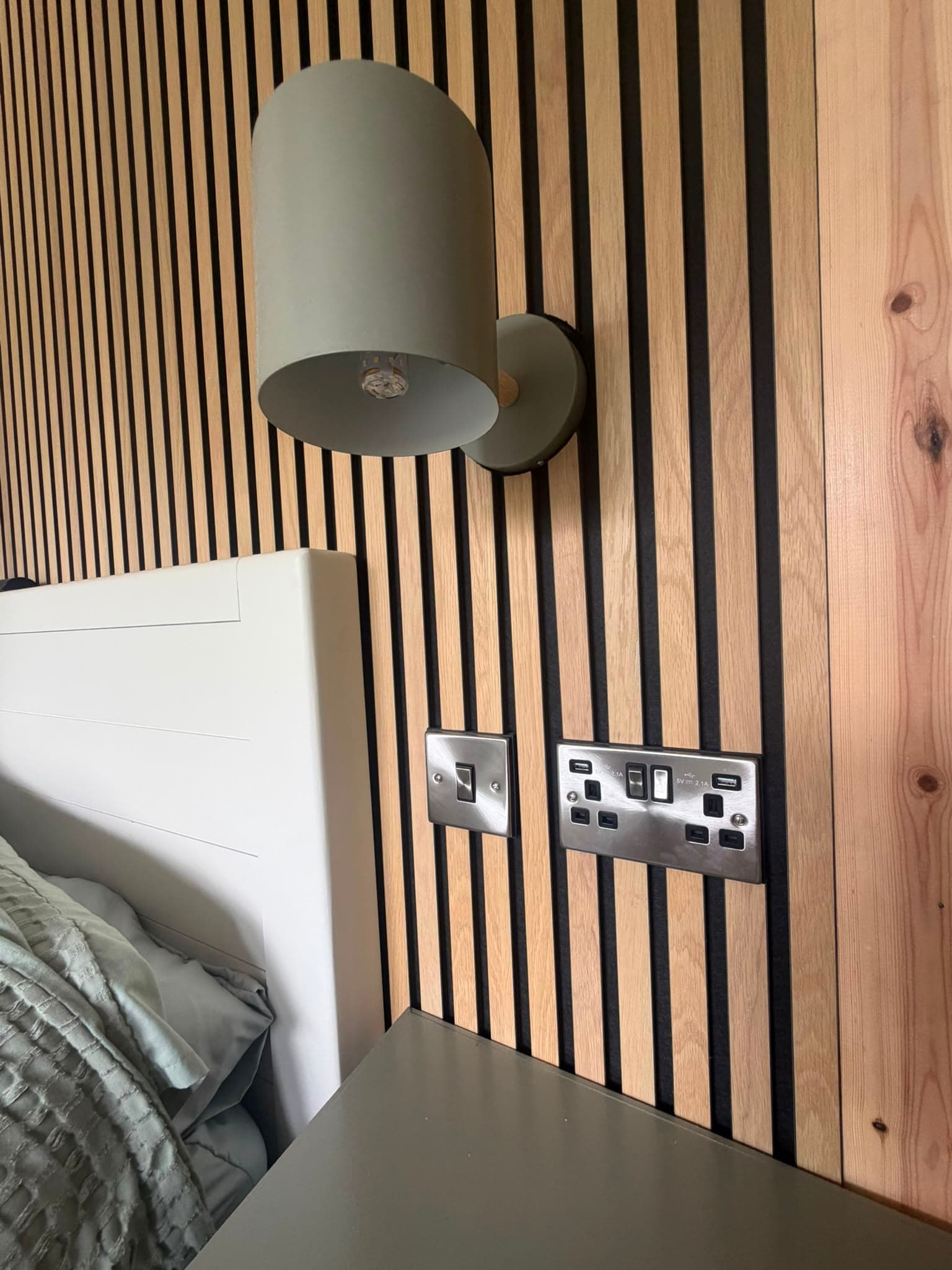 Newly-installed USB double socket and light switch on a bedroom feature wall